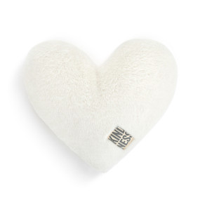A white heart shaped weighted pillow with a fabric tag that says "kindness".