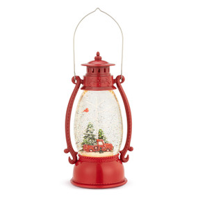 A lit red lantern with a snowy scene including a red truck, trees and a red cardinal inside.