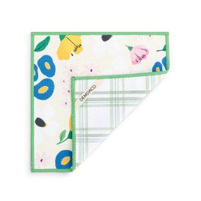 A double sided square dish cloth that is white on one side with colorful floral illustrations, displayed with one corner turned back.