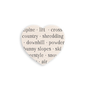 A set of four heart shaped white ceramic coasters with words about skiing on it.