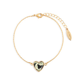 An adjustable gold chain bracelet with a heart shaped charm of the moon and clouds on a dark background.