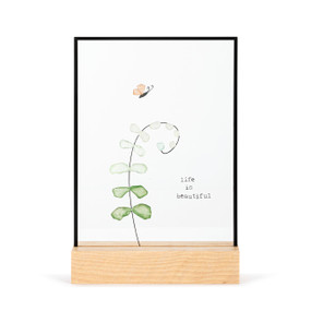 A large rectangular suncatcher in a light wood base. The image is a curving branch of leaves and a butterfly made from small colored stones and has the saying "life is beautiful".