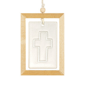 A hanging cream ceramic plaque with a cross suspended inside a light wood open frame.