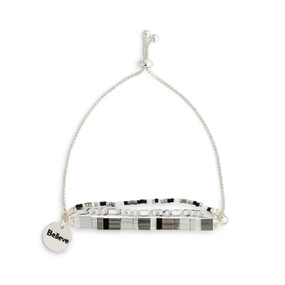 A silver chain adjustable bracelet with beads and tiles in silver, gray and black. The bracelet also has a silver round charm that says Believe.