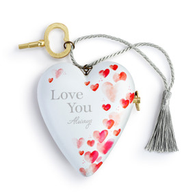 A heart shaped musical sculpture in a white with red hearts pattern that reads "Love You Always". The heart has a silver tassel and gold key attached.