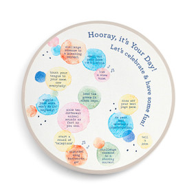 A white celebration lazy susan that says "Hooray, it's Your Day" with pastel dots that each have different party activities.