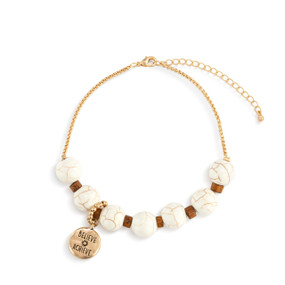 An adjustable gold chain bracelet with 7 white and gold beads. There is a round gold charm that says "Believe Achieve" that can move between the seven beads.