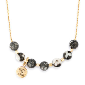 An adjustable gold chain necklace with seven gold and black beads spaced on it with a charm saying "Believe Achieve" that can move across the beads to track habits.