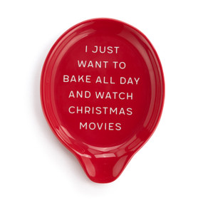 Top down view of a red ceramic spoon rest with the saying "I Just Want To Bake All Day And Watch Christmas Movies".