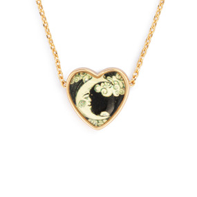 Detail view of the charm on an adjustable gold chain necklace with a heart shaped charm of a moon and clouds on a dark background.
