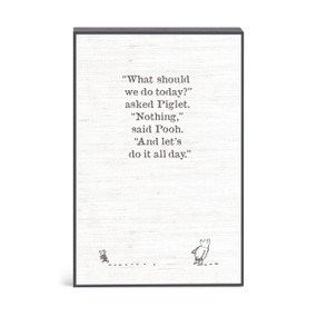 A wall art of Winnie-the-Pooh and Piglet with a message about doing nothing all day.
