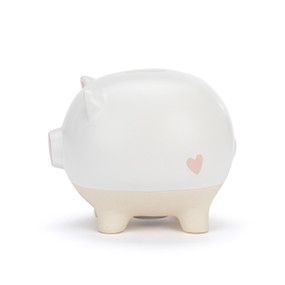 A white ceramic piggy bank with the face of a pig and a pink nose. The feet of the bank are cream and textured.