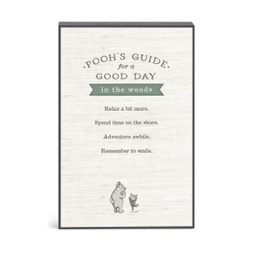 A wall art with an illustration of Pooh and Piglet with a message about Pooh's guide for a good day in the woods.