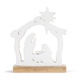 A cut out silhouette wood nativity painted white on a wood base.