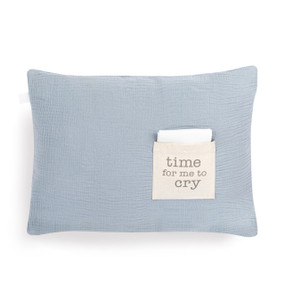 A light blue rectangular pillow with a cream fabric pocket on the front with the saying "time for me to cry". The pocket has a white fabric folded in it.