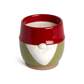 A green round ceramic filled candle with the nose and beard of a gnome in white with a red rim.