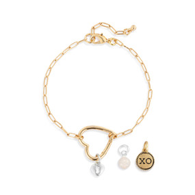 A gold chain bracelet with an open heart that is used to place other charms on.