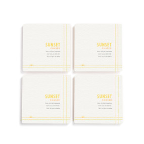 A set of four white square coasters with a basic recipe for a Sunset Chaser written in yellow.