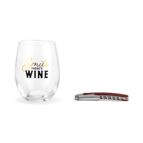 Clear stemless wine glass with the saying "Smile There's Wine" next to a wood handled corkscrew.