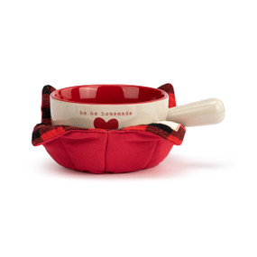 A cream handled soup bowl with a red interior inside a red fabric cozy. The bowl says "ho ho homemade" with a red heart.
