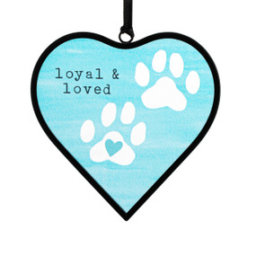 A small light blue heart shaped sun catcher with an illustration of paw prints and the saying "loyal & loved".