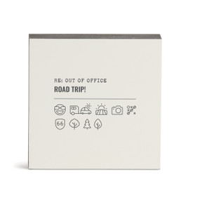 A white square wall art with the saying "RE: Out of Office Road Trip!" with a set of emoji images related to road trips.
