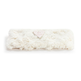 A cream rectangular eye pillow with a heart shaped diffuser in the middle.