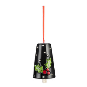 A black ceramic bell with white dots and raised holly leaves and berries on the front.