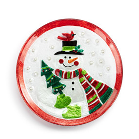A mini round glass plate with the image of snowman in a striped scarf holding a tree with a red bird on his top hat.