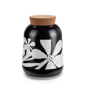 A round black ceramic canister with a bold white flower pattern. The canister has a cork lid.