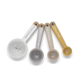 A set of yellow, gray and white measuring spoons with the measurements inside the spoon and Winnie-the-Pooh type sayings on the handles.