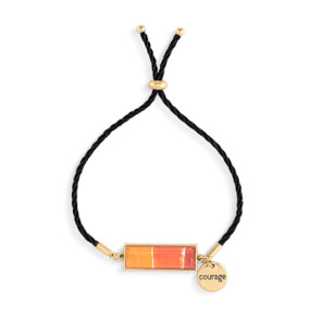 An adjustable black string bracelet with a horizontal gold charm with shades of orange artwork inspired by ArtLifting artist Christina Constantine. The bracelet also has a small round gold token that says "courage".