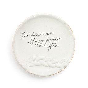 A small white round ceramic trinket dish with a raised braid pattern on the bottom half with the saying "two became one...Happy forever after." in the middle.