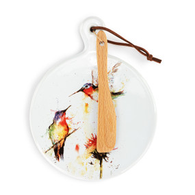 A round ceramic white mini serving board with watercolor hummingbirds and a flower. The board has a small wood knife attached.