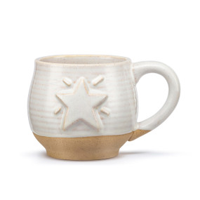 A cream ceramic mug with a tan textured base and cream interior. The mug has a raised star on the front.