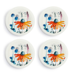 A set of four white melamine appetizer plates with meadow flowers in the middle, displayed set out next to each other.