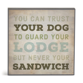 A square brown wall art with the saying "You can trust your dog to guard your lodge but never your sandwich".