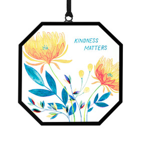A small octagon shaped sun catcher with illustrated yellow flowers and the saying "Kindness Matters".