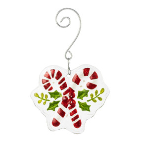 A glass ornament of two crossed candy canes and holly leaves with a curved silver hanger.
