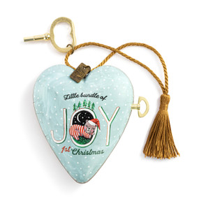 A light blue heart shaped musical sculpture with the saying "Little bundle of Joy 1st Christmas" with a little bear sleeping in the O of Joy. The heart has a gold tassel and gold key attached.