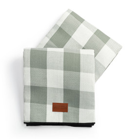 A large green and cream plaid outdoor blanket with a small leather patch that says "A Happy Family gathers outside".