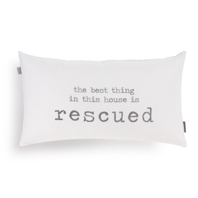 A white rectangular pillow that says "the best thing in this house is rescued" in gray type.