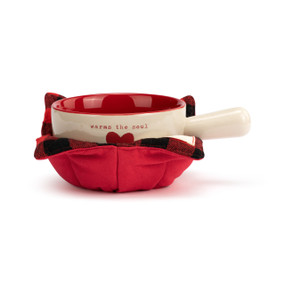 A cream handled soup bowl with a red interior inside a red fabric cozy. The bowl says "warms the soul" with a red heart.