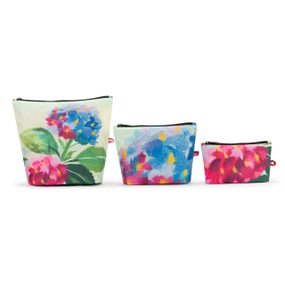 A set of three zippered fabric pouches with blue and pink hydrangea floral artwork inspired by Artlifting artist Midori. The bags are in three different sizes.