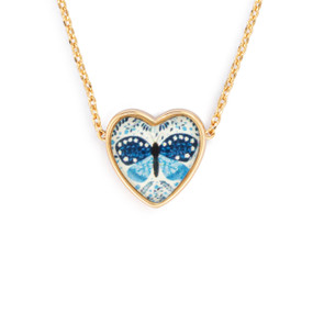Detail view of the charm on an adjustable gold chain necklace with a heart shaped charm of a blue butterfly.