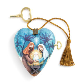A blue heart shaped musical sculpture with an image of the holy family. The heart has a gold tassel and gold key attached.