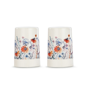 A set of two white ceramic salt and pepper shakers with a cream textured base. There is an image of meadow flowers on them.