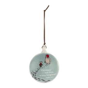 A round disc ornament with the image of Pooh and Piglet walking in snow and the saying "Christmas" said Pooh, "is even brighter with you.".