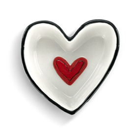 Top down view of a small heart shaped dish with a red heart on the inside.