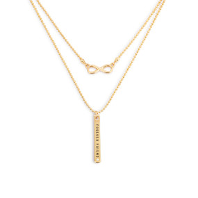 Detail view of the charms on an adjustable gold layered necklace with an infinite symbol charm on one layer and a band that says "Forever Friend" on the other.